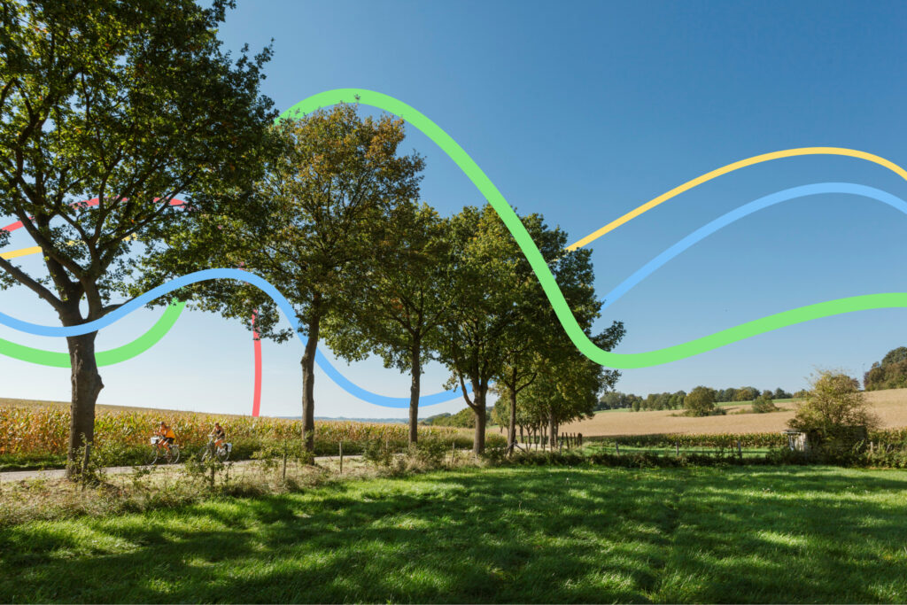 Twee fietsers rijden door het Limburgse landschap.